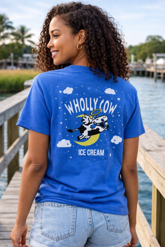 Person wearing a blue t-shirt with 'Wholly Cow Ice Cream' design by a shem creek Mount Pleasant waterfront.